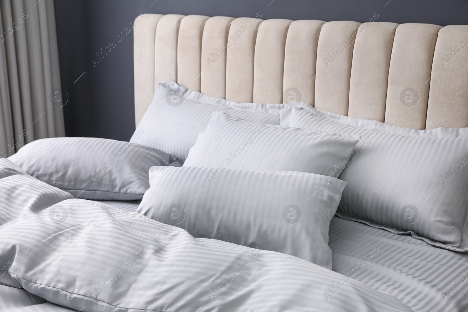 Photo of Comfortable bed with soft blanket and pillows indoors