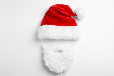 Photo of Santa Claus hat with beard on white background, top view