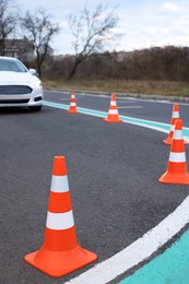 Photo of Modern car at test track, focus on traffic cone. Driving school