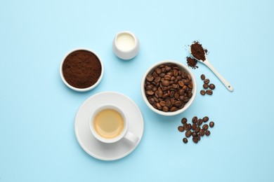Flat lay composition with ground coffee and roasted beans on light blue background