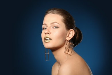 Photo of Portrait of beautiful lady with gold lipstick on color background