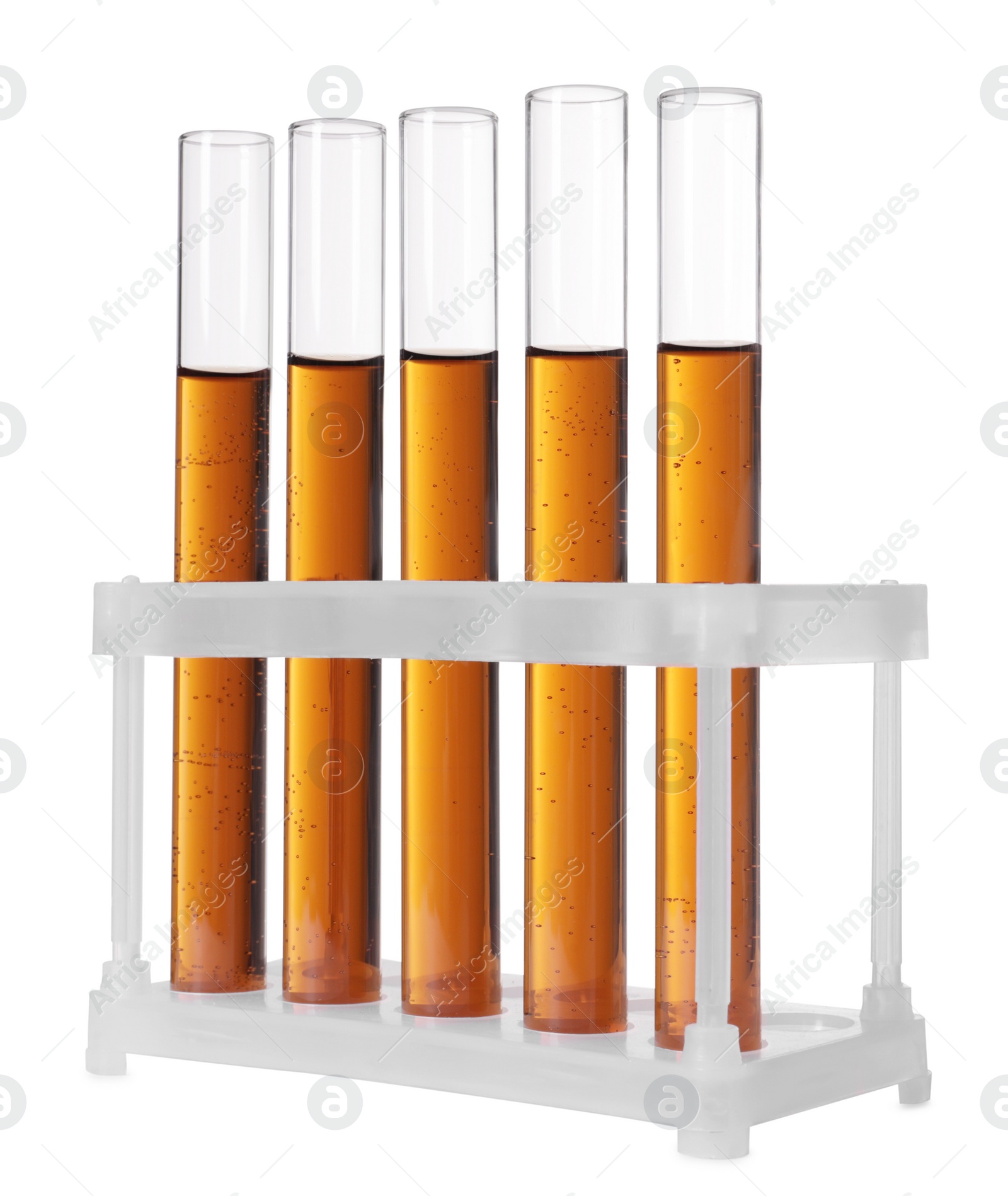 Photo of Test tubes with brown liquid in stand on white background