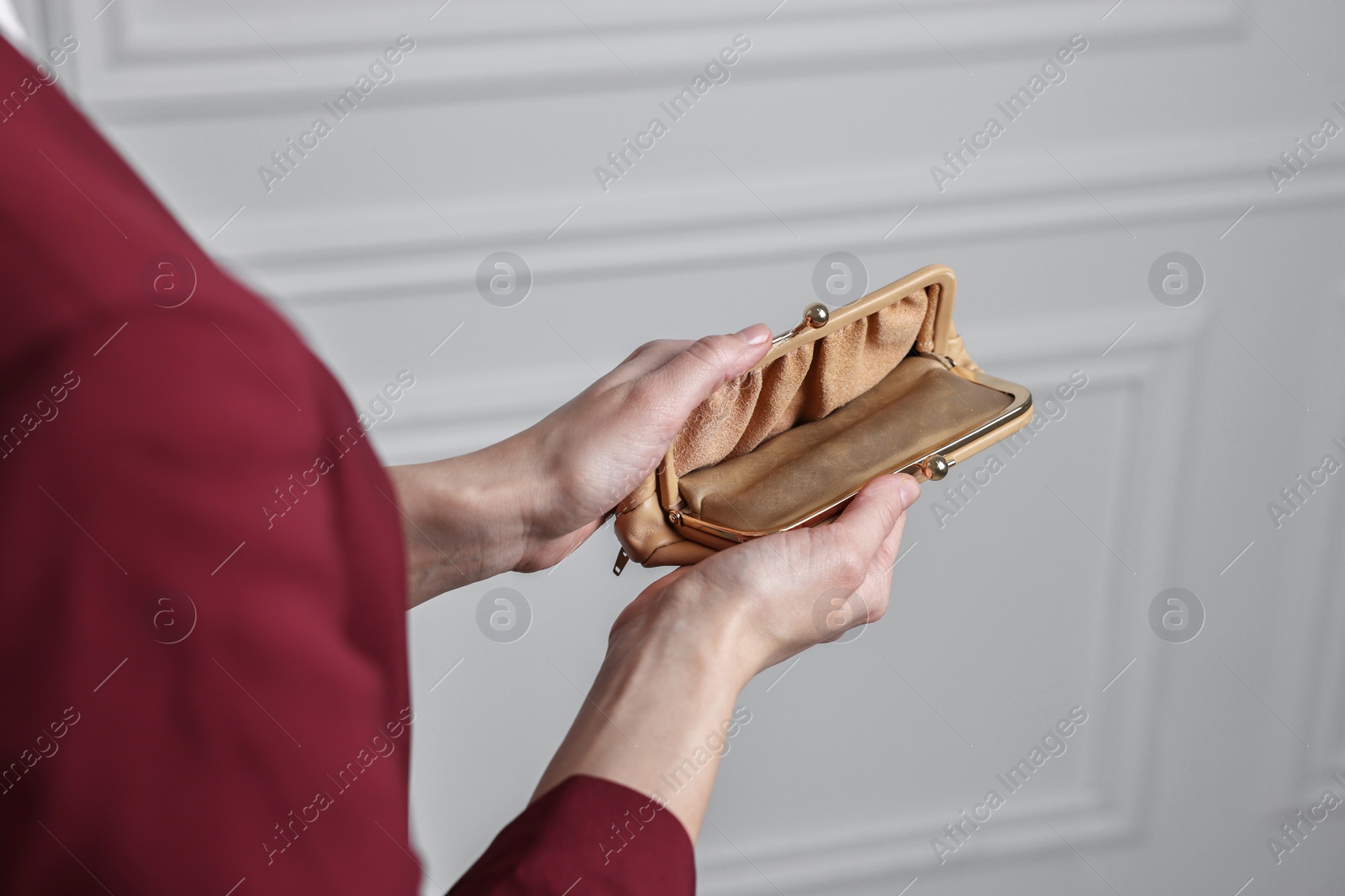 Photo of Woman with empty wallet near white wall, closeup