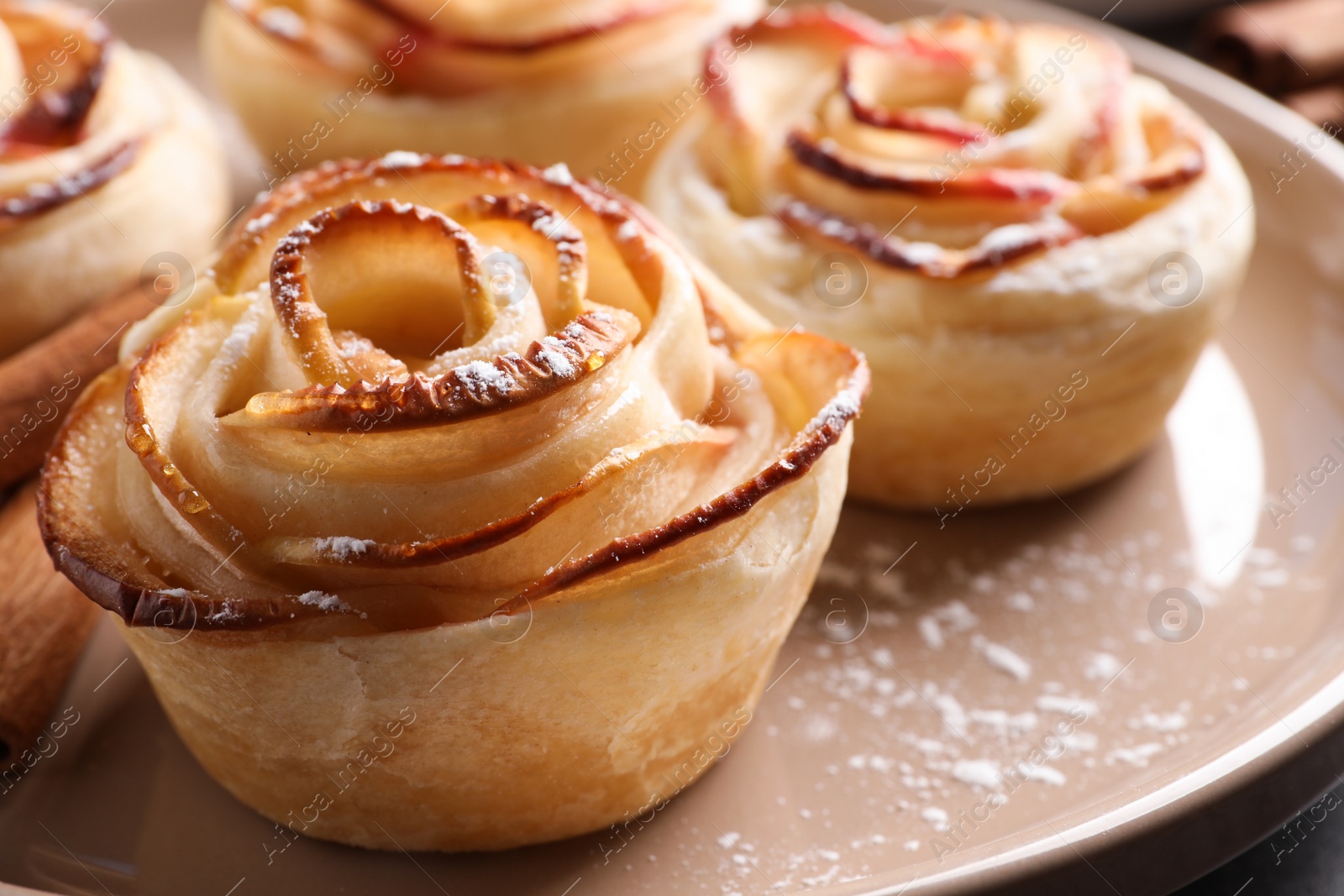 Photo of Freshly baked apple roses on plate, closeup. Beautiful dessert