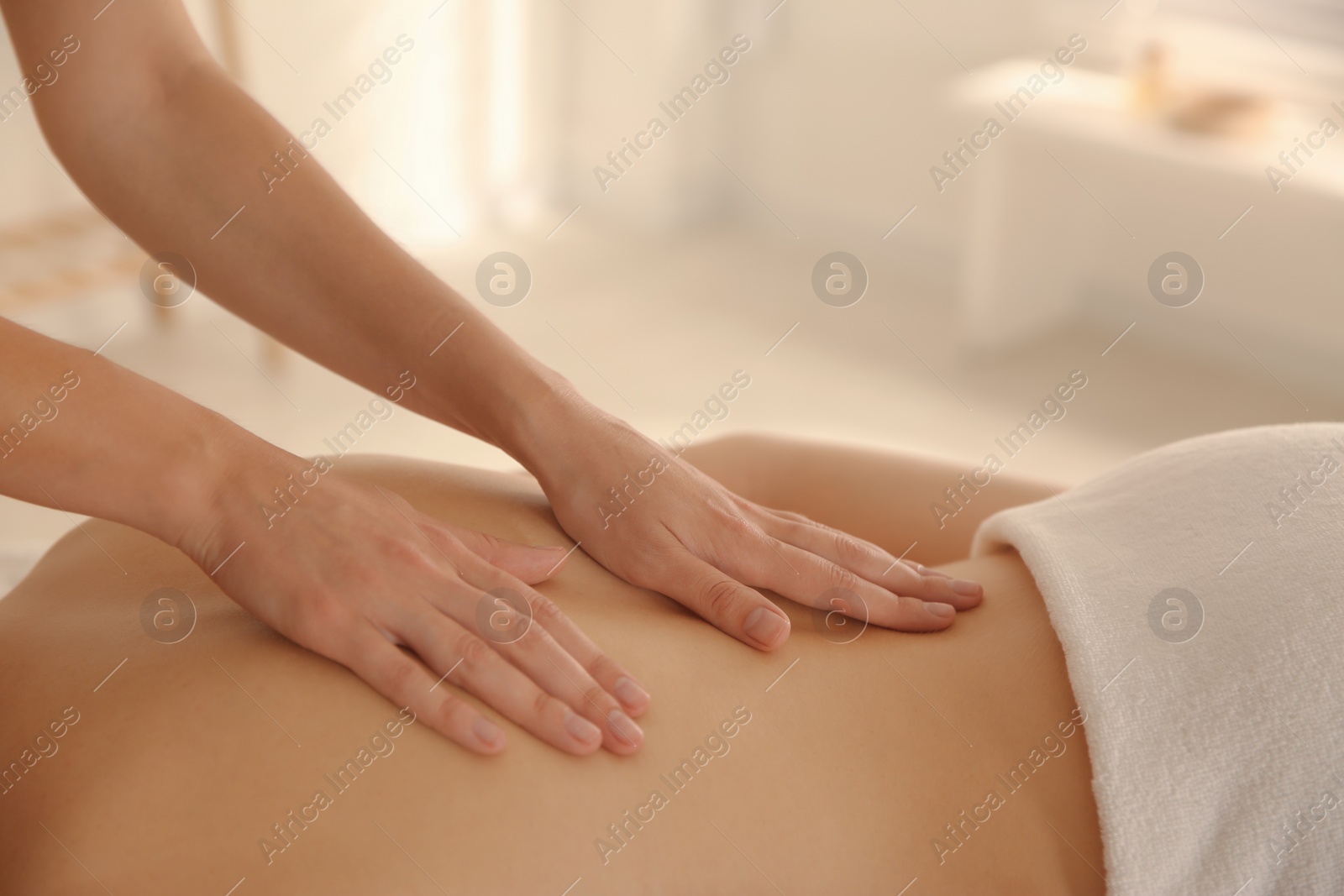 Photo of Young woman receiving back massage in spa salon, closeup