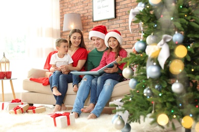 Photo of Happy parents and children reading fairy tales together at home. Celebrating Christmas