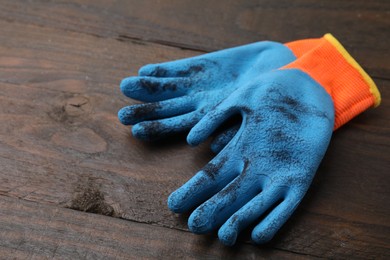 Photo of Pair of color gardening gloves on wooden table, space for text