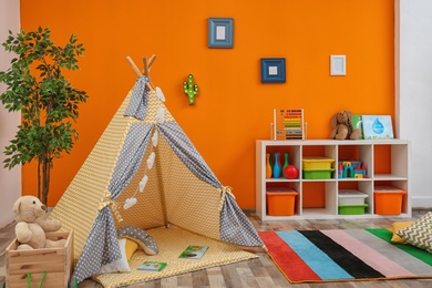 Photo of Cozy kids room interior with play tent and toys