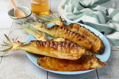 Photo of Tasty grilled pineapples on light gray table, closeup