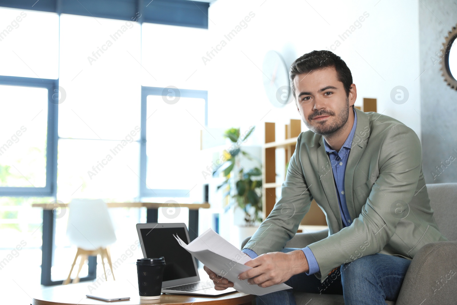 Photo of Male business trainer working with documents in office