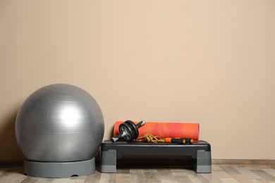 Photo of Set of fitness inventory on floor near color wall. Space for text