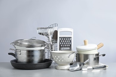 Photo of Set of clean kitchenware on light background