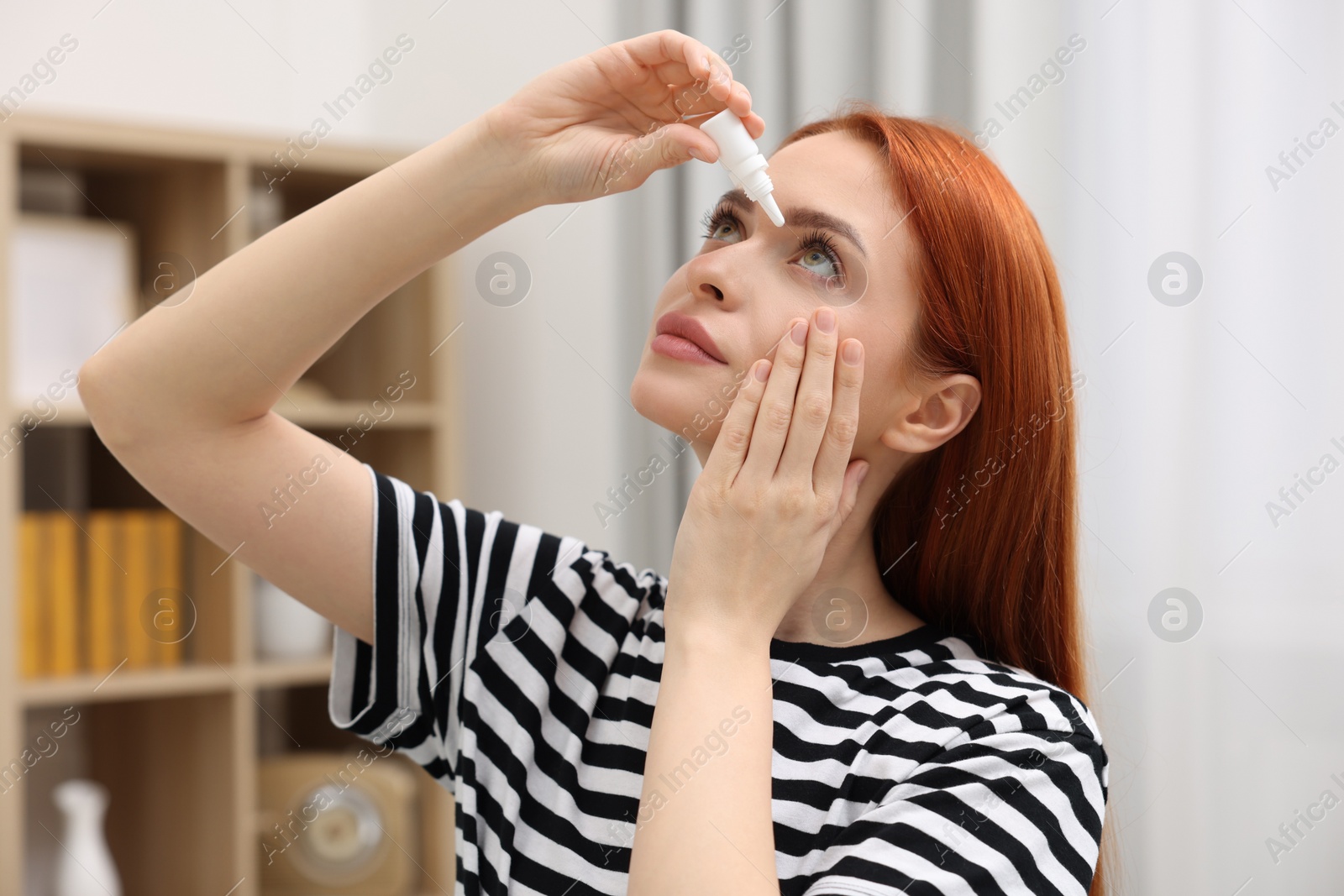 Photo of Woman applying medical eye drops at home