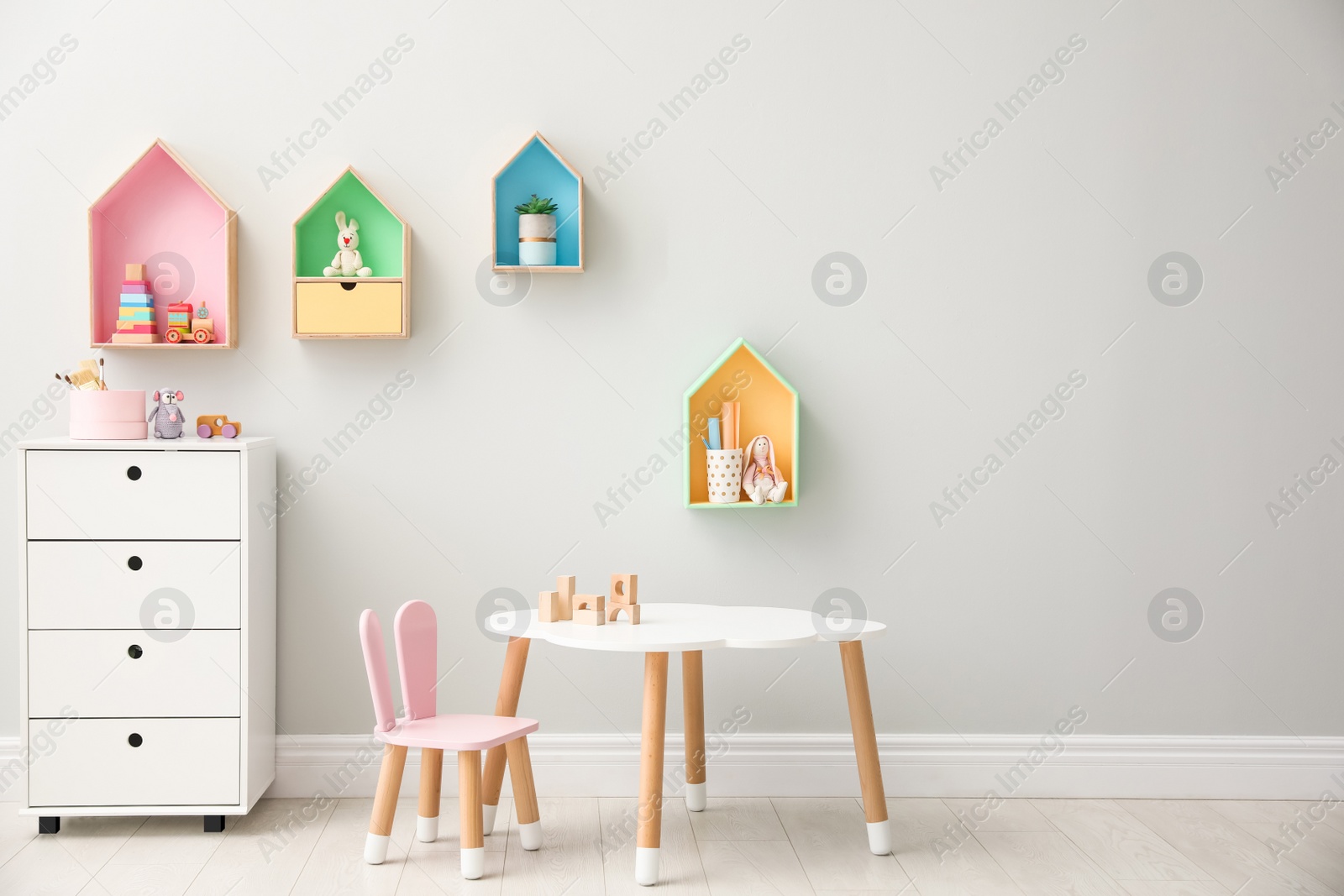 Photo of Children's room interior with house shaped shelves and little table