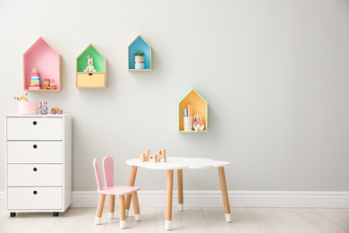 Children's room interior with house shaped shelves and little table