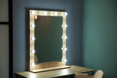 Photo of Beautiful mirror with lamps in modern makeup room