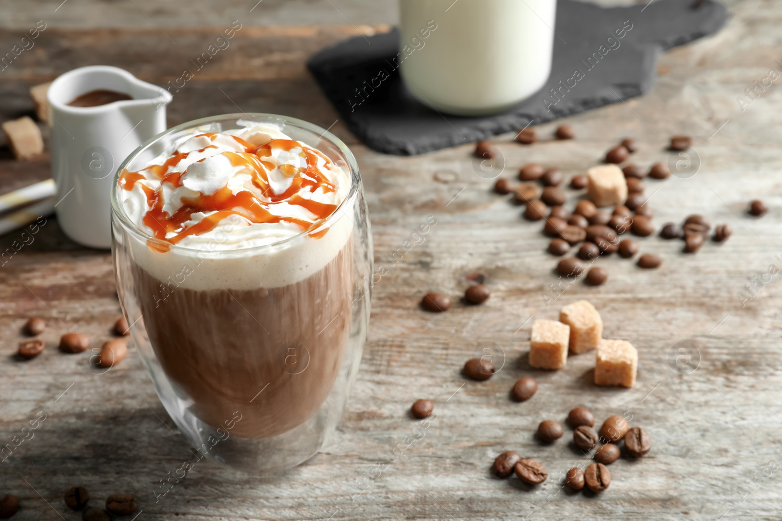 Photo of Glass of coffee with caramel topping on wooden background