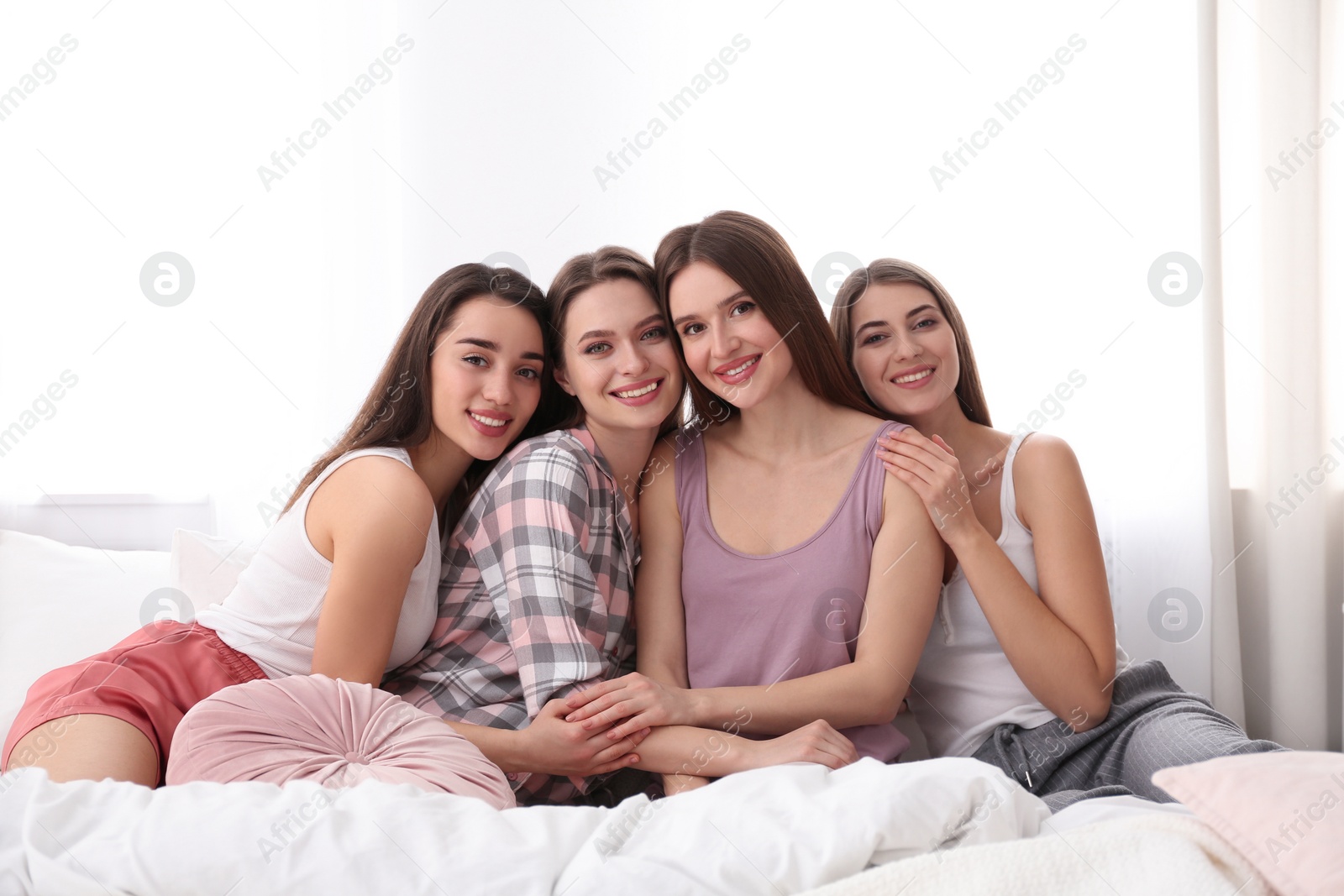 Photo of Beautiful young ladies on bed at pamper party. Woman's Day