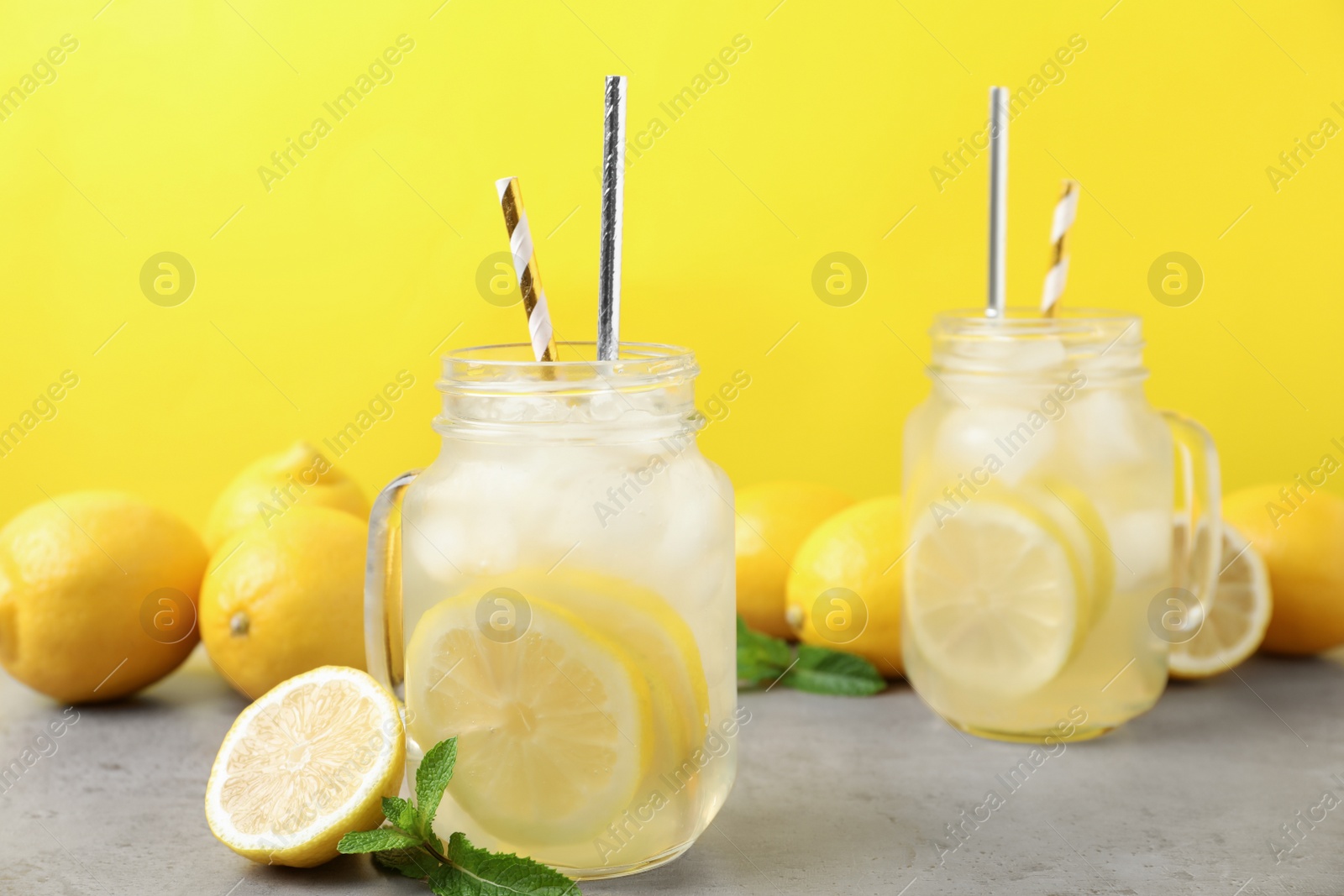 Photo of Natural freshly made lemonade with mint on light grey table. Summer refreshing drink