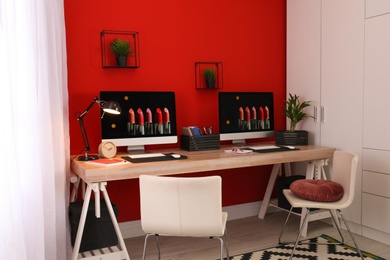 Photo of Modern workplace with large desk and computers in room. Stylish interior