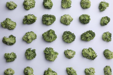 Many fresh green broccoli pieces on white background, flat lay