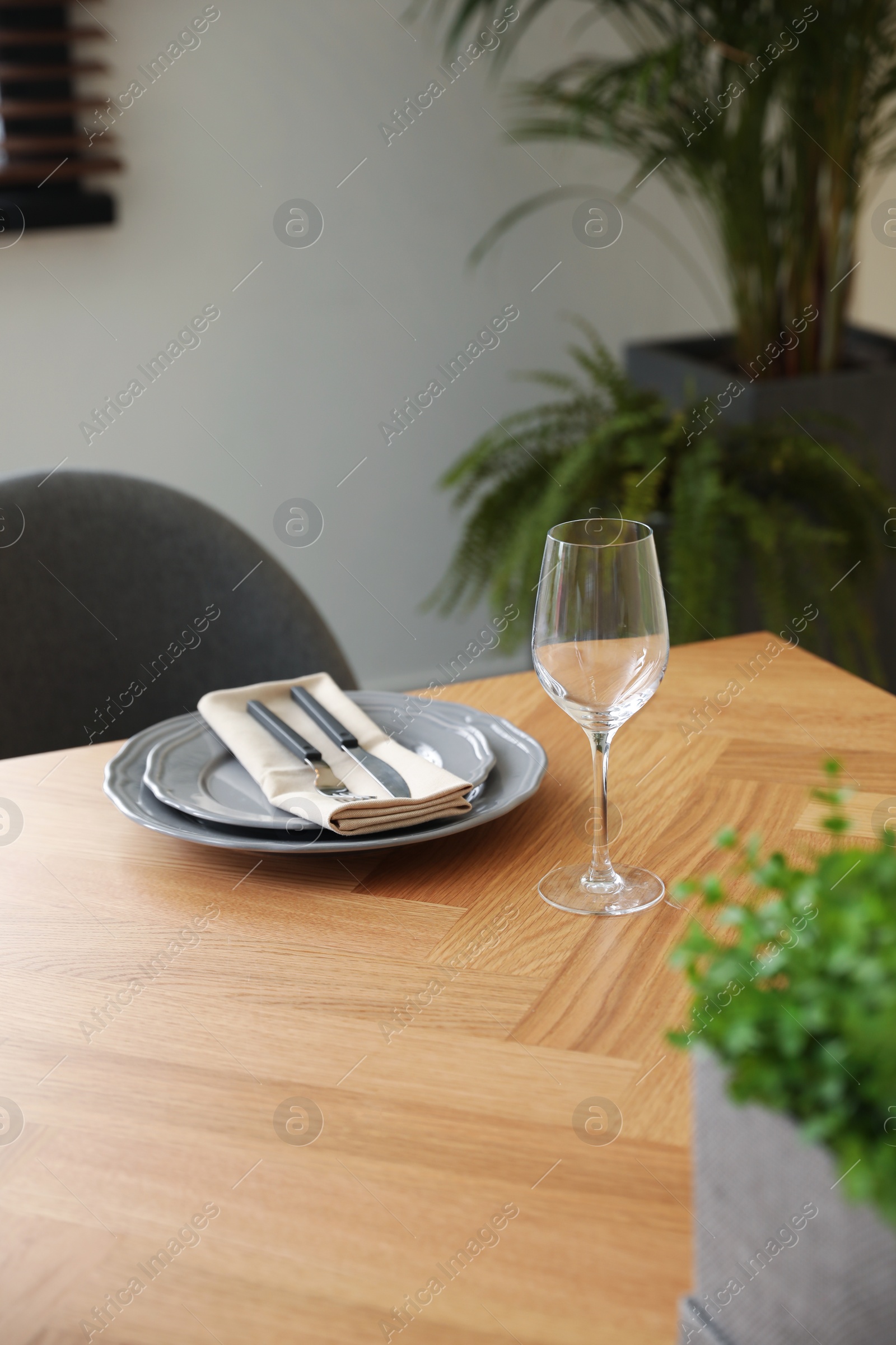 Photo of Glass and plates on wooden table in dining room