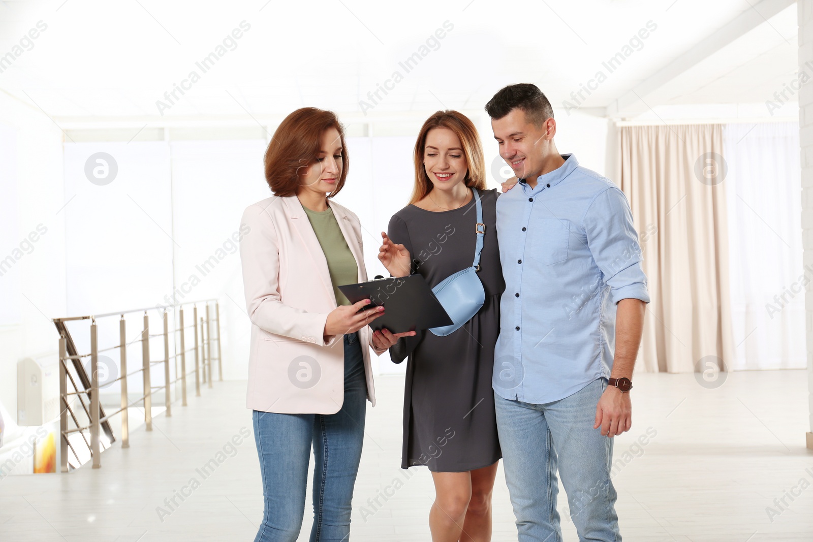 Photo of Real estate agent showing new apartment to young couple