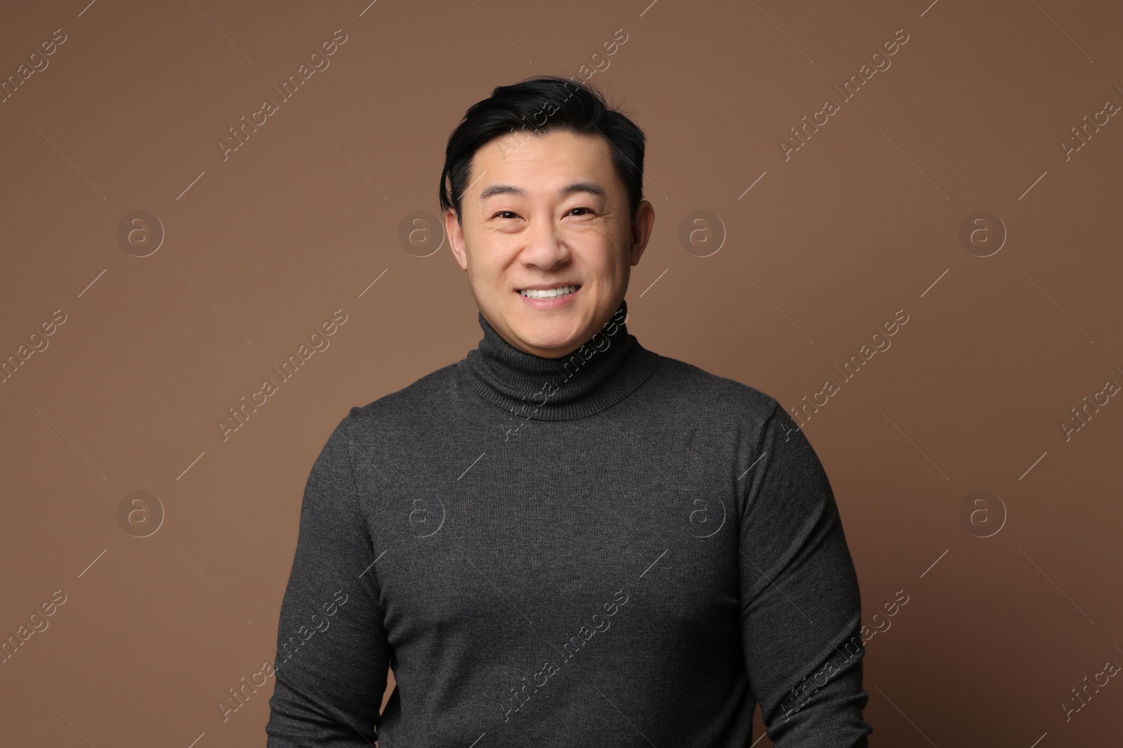 Photo of Portrait of happy man on brown background