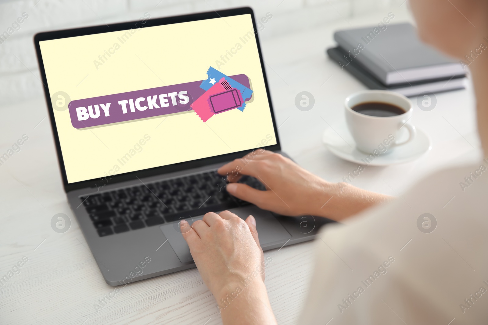 Image of Woman buying tickets online via laptop at table, closeup