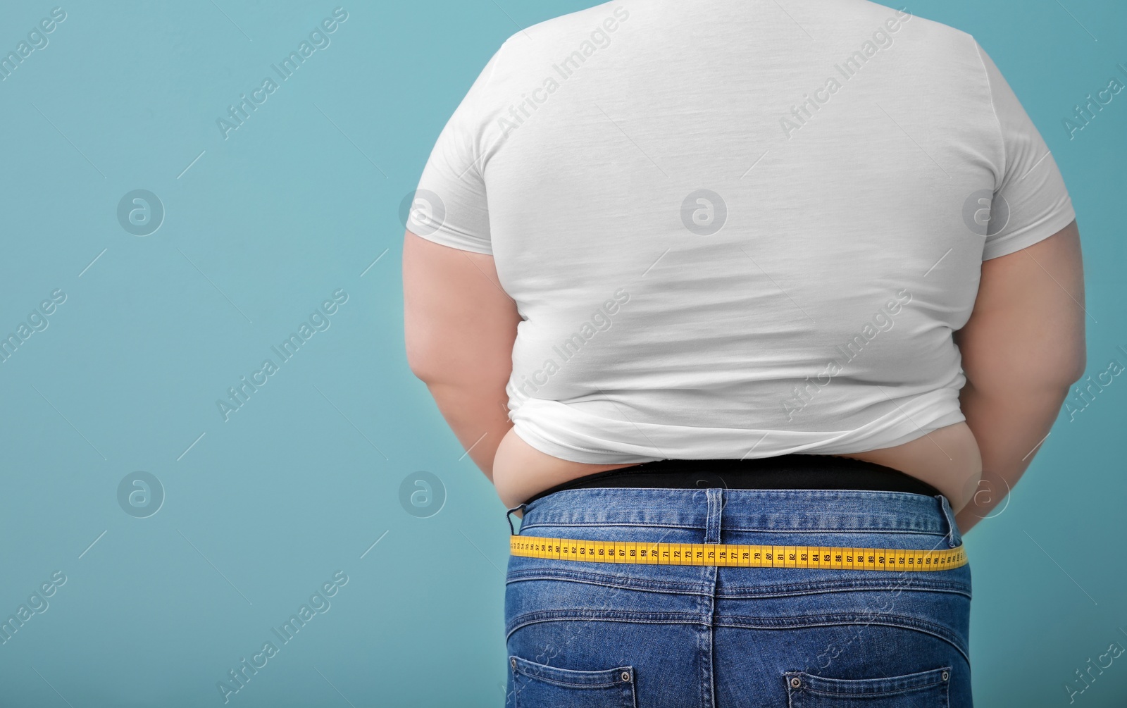 Photo of Overweight woman with measuring tape on color background