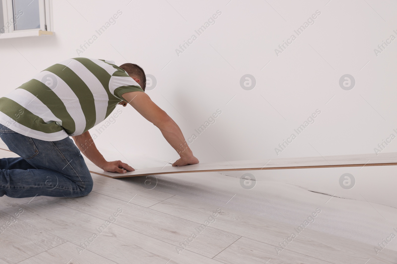 Photo of Professional worker installing new laminate flooring indoors