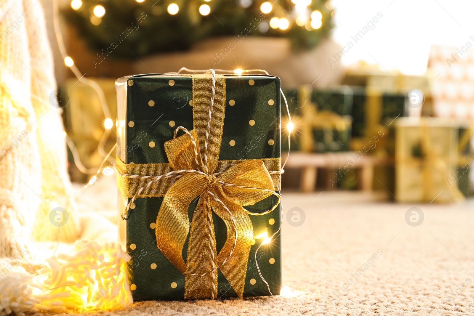 Photo of Beautiful Christmas gift and blurred pile of presents on background. Space for text