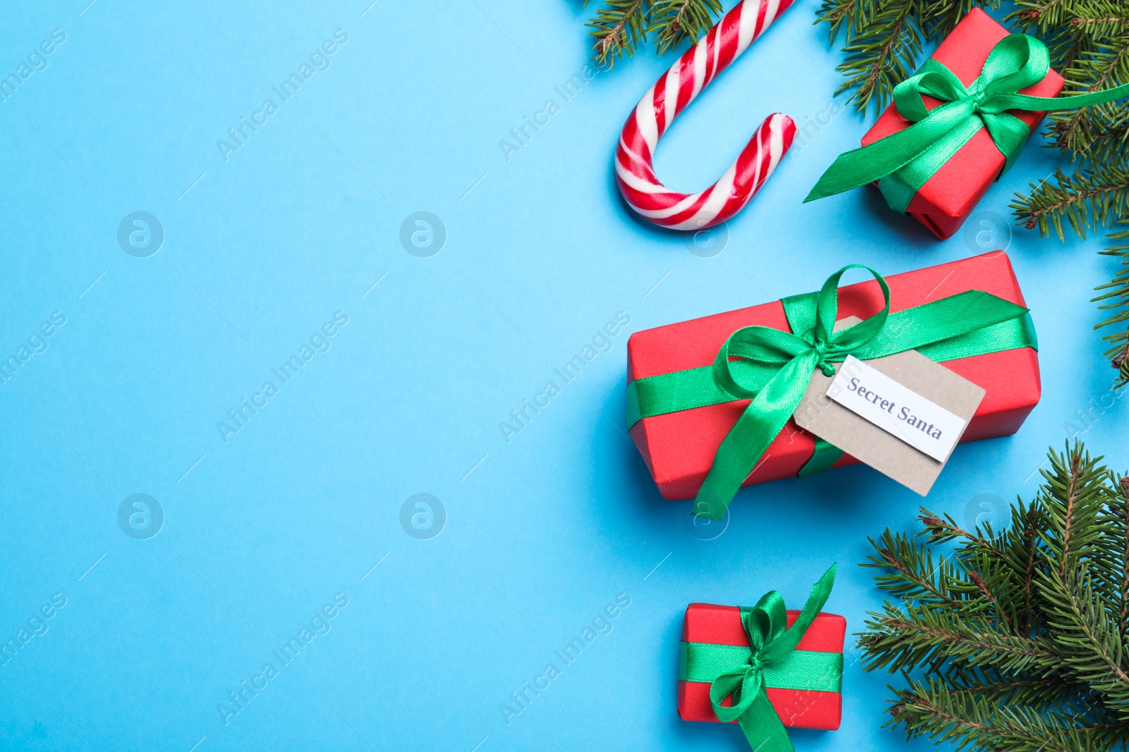 Photo of Flat lay composition with presents from secret Santa on light blue background, space for text