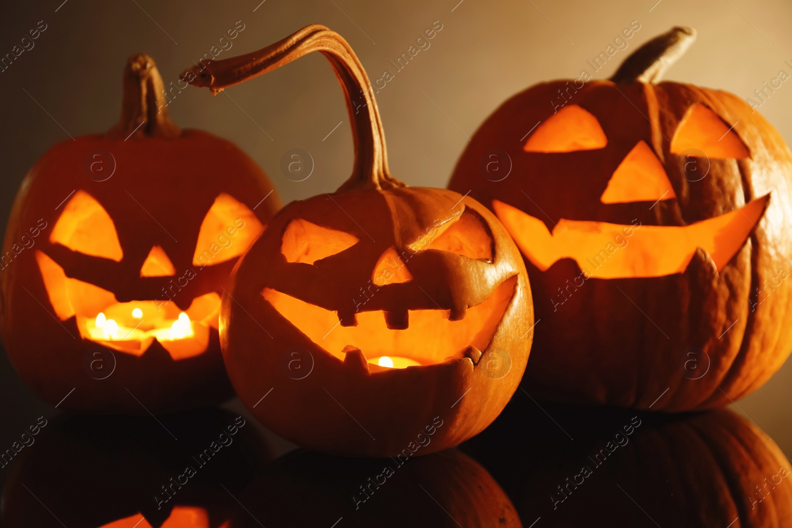 Photo of Halloween pumpkin heads. Glowing jack lanterns on dark background