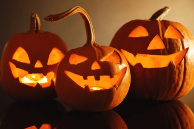 Photo of Halloween pumpkin heads. Glowing jack lanterns on dark background