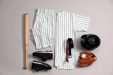 Baseball uniform and other sports equipment on white background, flat lay
