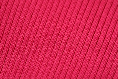 Texture of soft red knitted fabric as background, closeup