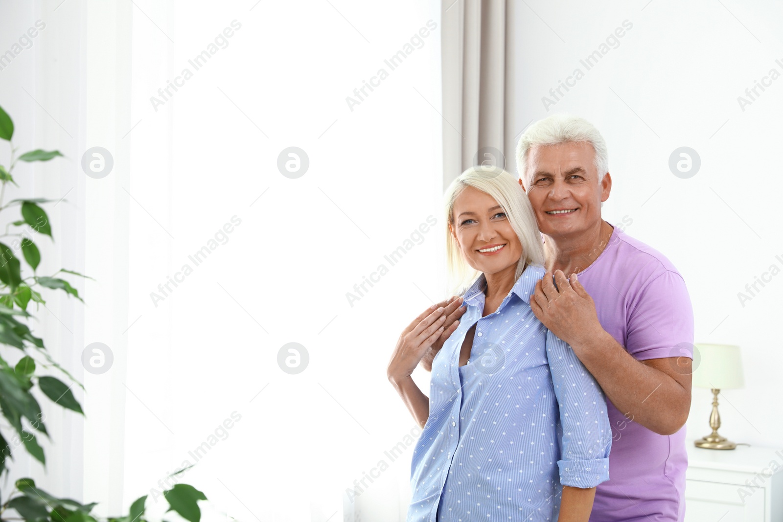 Photo of Portrait of happy senior couple at home. Space for text