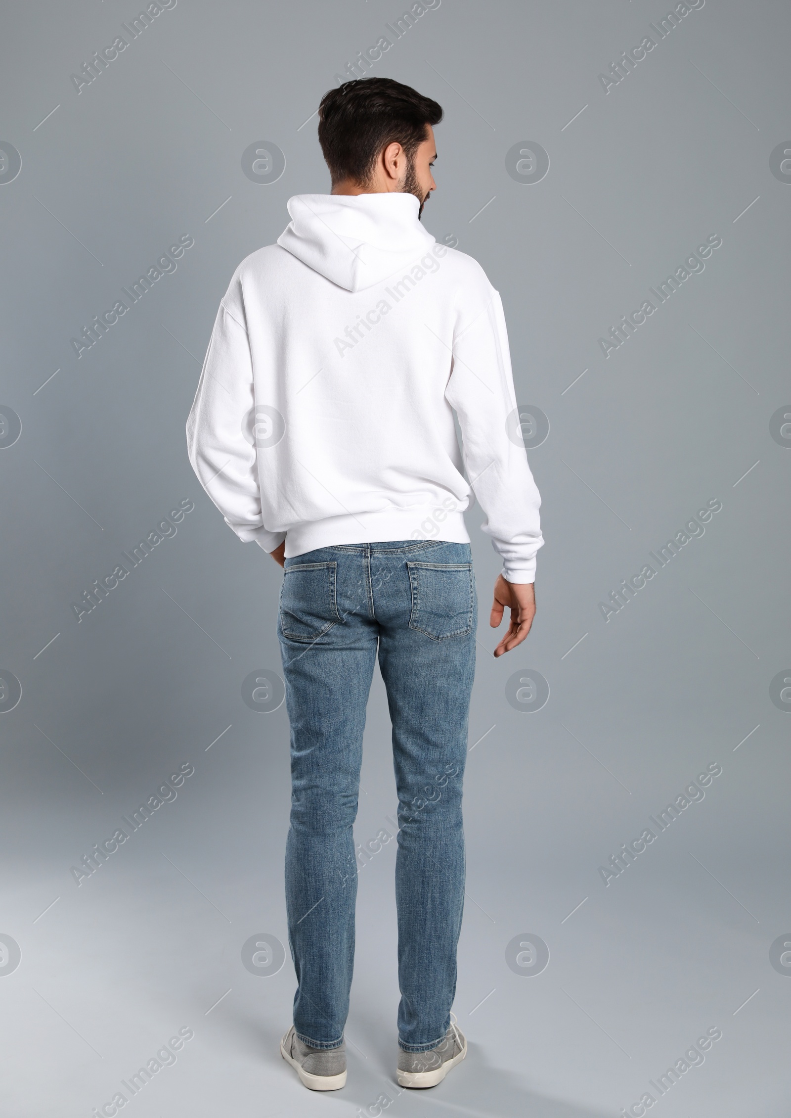 Photo of Young man in sweater on grey background. Mock up for design