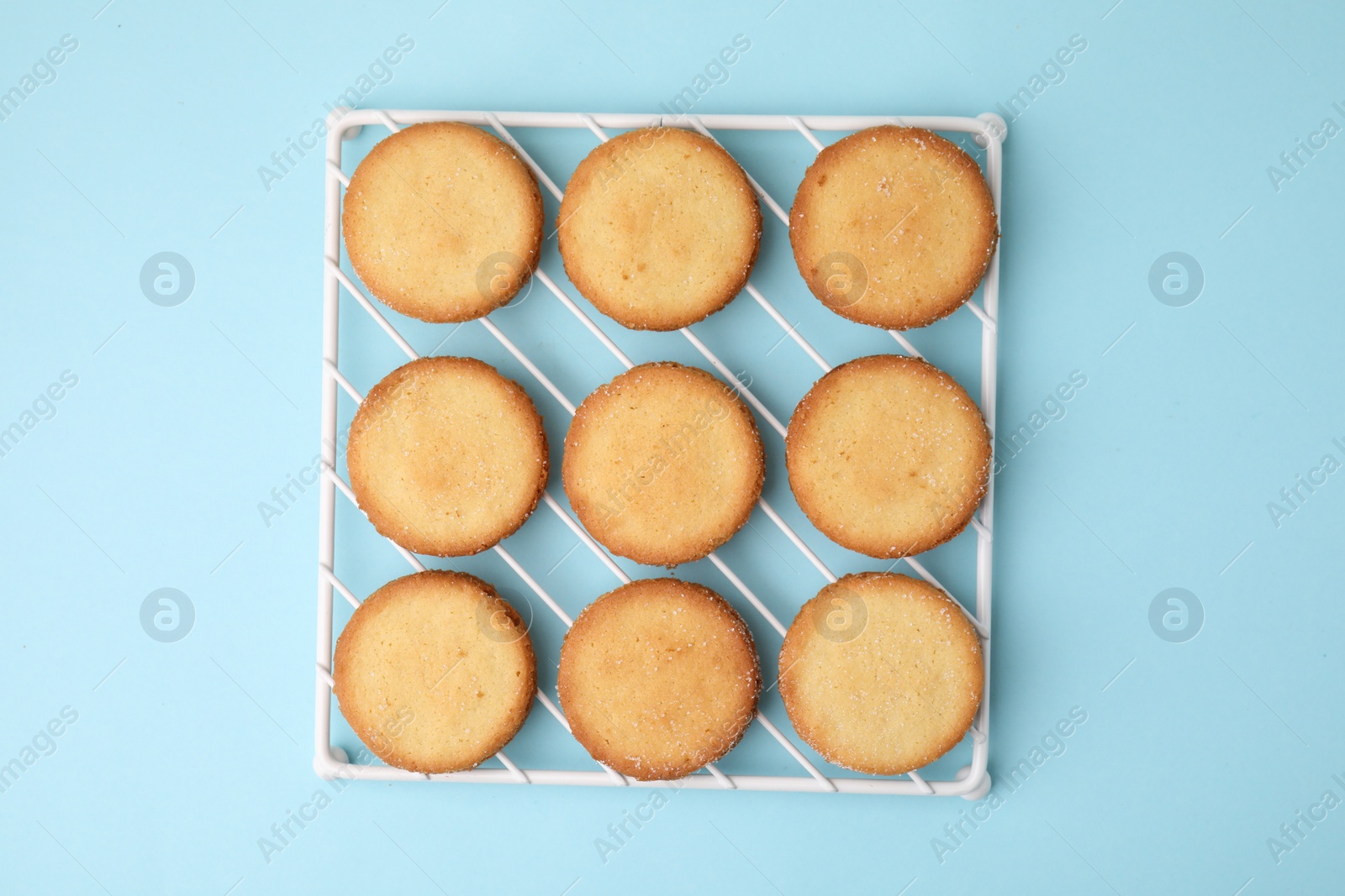 Photo of Tasty sweet sugar cookies on light blue background, top view