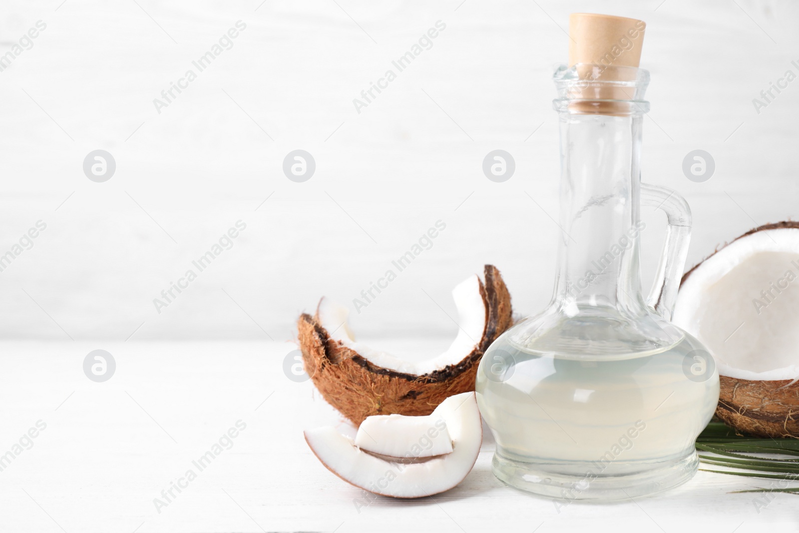 Photo of Coconut oil on white wooden table. Space for text