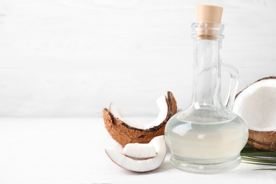 Coconut oil on white wooden table. Space for text