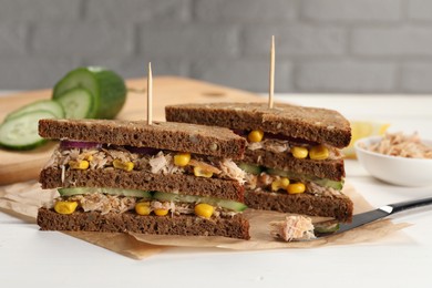 Delicious sandwiches with tuna and vegetables on white table