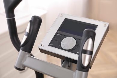 Control panel of modern elliptical machine cross trainer on blurred background, closeup