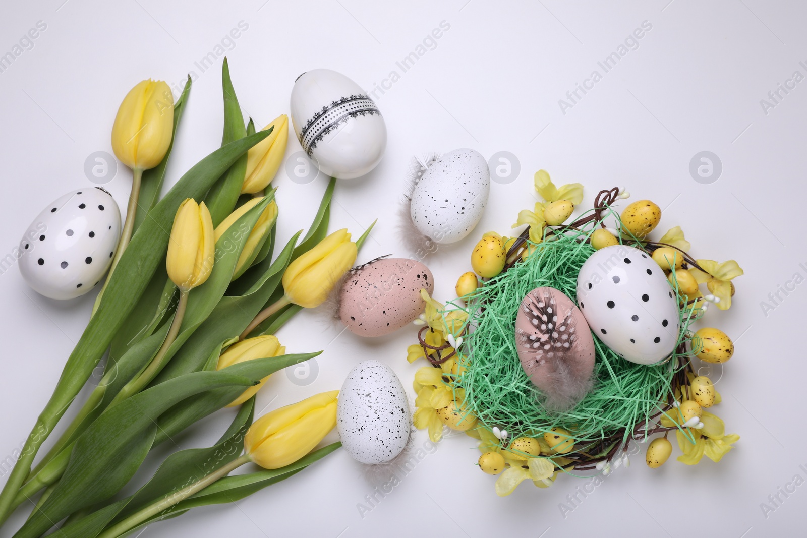 Photo of Flat lay composition with beautiful flowers and eggs on white background. Easter celebration