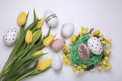 Photo of Flat lay composition with beautiful flowers and eggs on white background. Easter celebration