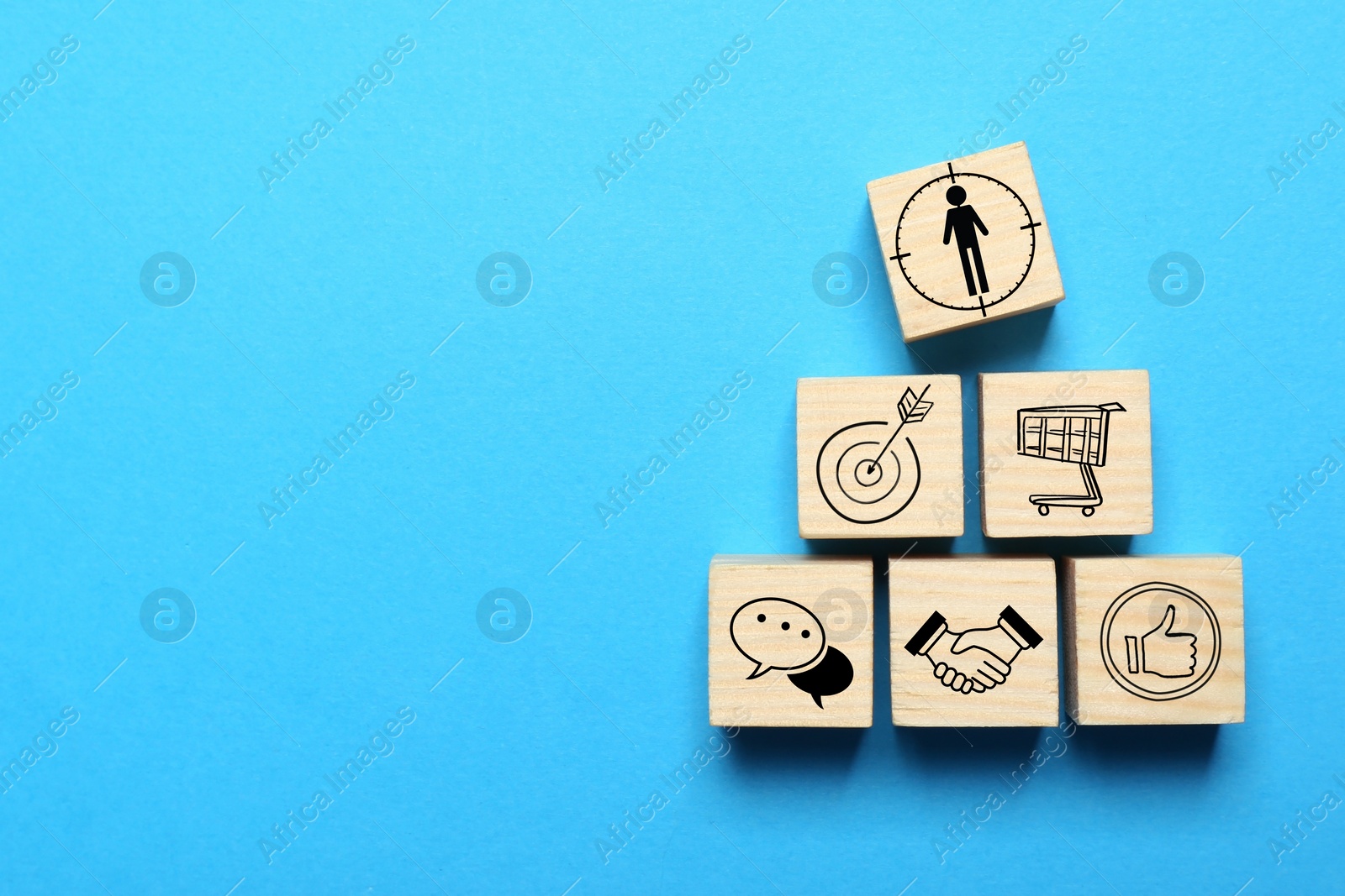 Image of Professional buyer. Wooden cubes with different icons on light blue background, top view