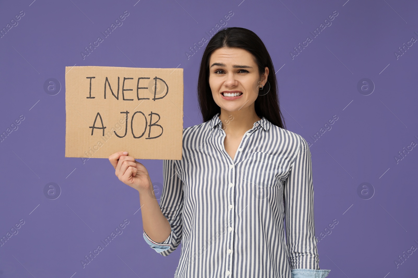 Photo of Unemployment problem. Unhappy woman holding sign with phrase I Need A Job on violet background