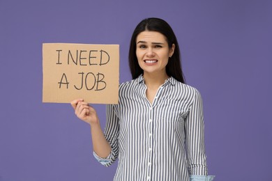 Unemployment problem. Unhappy woman holding sign with phrase I Need A Job on violet background