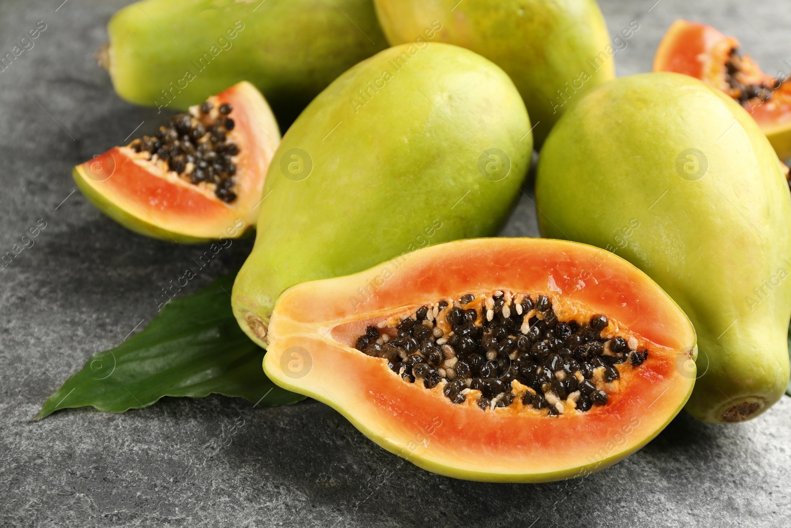 Photo of Fresh ripe papaya fruits on grey table